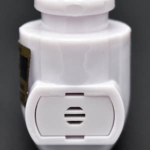May include: White plastic bottle stopper with a small, rectangular vent on the side. The stopper has a rounded top and a slightly pointed bottom.