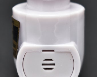 May include: White plastic bottle stopper with a small, rectangular vent on the side. The stopper has a rounded top and a slightly pointed bottom.