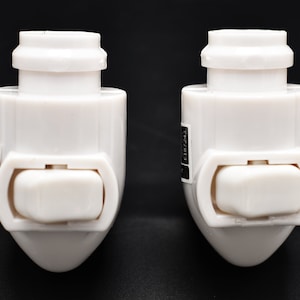May include: Two white plastic electrical outlet adapters with a built-in on/off switch. The adapters have a black label with the text "125V 15A" printed on them.