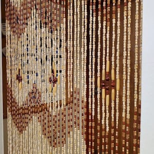 May include: A wooden beaded curtain with alternating light brown and dark brown beads. The curtain is hanging in a doorway.
