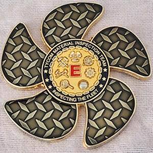 May include: A gold and black metal spinner with a diamond plate pattern on the blades. The center features a gold emblem with the text "TYCOM MATERIAL INSPECTION TEAM INSPECTING THE FLEET" and a red "E".