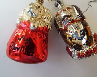 May include: Two vintage glass Christmas ornaments shaped like dogs. One is red with gold trim and the words "My Darling" written on it. The other is silver with gold trim and brown accents.