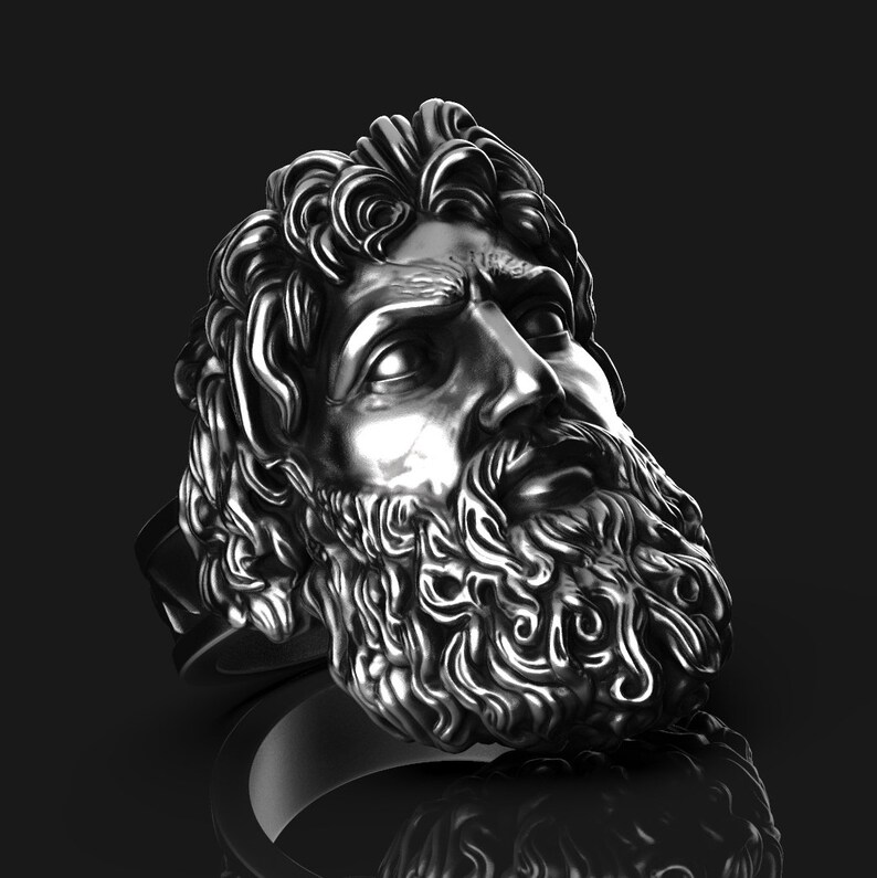 May include: A silver ring with a detailed sculpture of a man's face with a beard. The man's face is looking to the right.