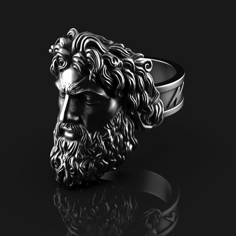 May include: A silver ring with a detailed sculpture of a man's face with a beard and long hair. The ring is a statement piece with a unique design.