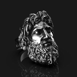 May include: A silver ring with a detailed sculpture of a man's face with a beard.