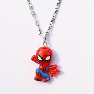 May include: A silver chain necklace with a red and blue cartoon Spider-Man pendant.