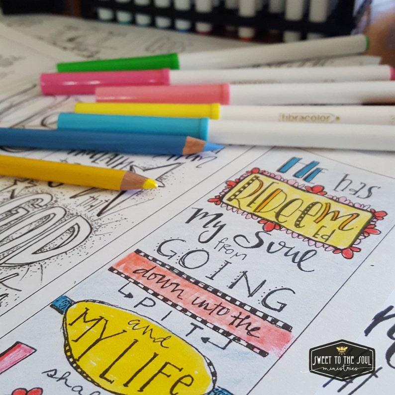 May include: A coloring page with the text "He has redeemed my soul from going down into the pit and my life" with colorful hand-drawn lettering. The page is partially colored with pink, yellow, orange, and blue.