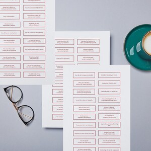 May include: Three sheets of paper with red-bordered boxes containing affirmations. The text in the boxes is in black. A cup of cappuccino in a green saucer is in the top right corner. A pair of spectacles is in the bottom left corner.