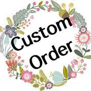 May include: A floral wreath with the text "Custom Order" in the center. The wreath is made of green leaves, pink, blue, and yellow flowers, and a brown acorn.