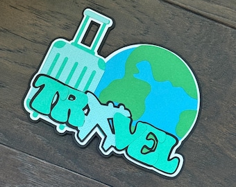 May include: A die-cut sticker featuring a light mint green suitcase, a blue and green globe, and a small airplane silhouette. The word TRAVEL is written in bold, layered, mint green graffiti-style lettering across the bottom of the design.