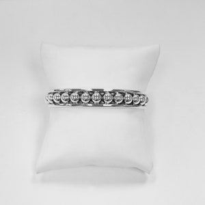 Puede incluir: Una pulsera de plata con una fila de cuentas redondas.