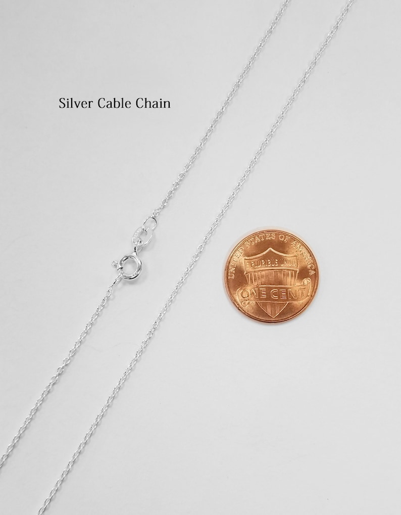 May include: A silver cable chain necklace laid out on a white surface next to a US penny for size comparison.  Silver Cable Chain.