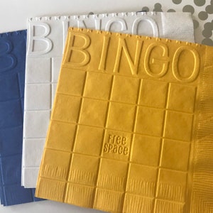 May include: Three bingo cards, one blue, one white, and one yellow. The yellow card has the word "BINGO" at the top and "Free Space" in the center.