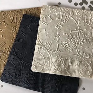 May include: Three paper napkins with an embossed clock face design. The napkins are in black, brown, and white.