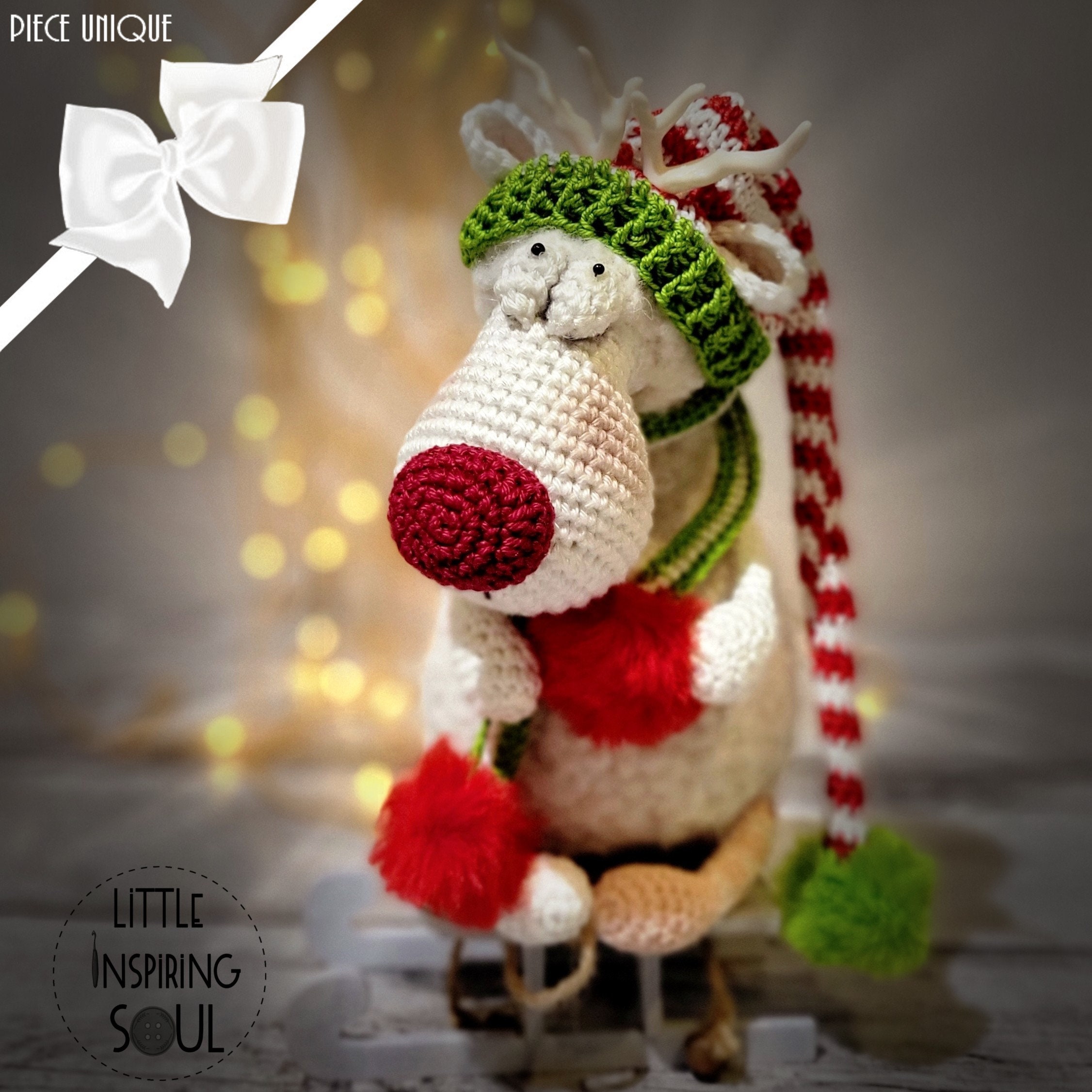 Renne de Noël blanc au crochet avec son bonnet blanc et rouge de noël et son écharpe à pompons à adopter