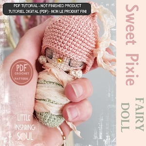 Puede incluir: Un patrón de crochet para una dulce muñeca hada pixie. La muñeca está envuelta en una tela verde y rosa y lleva un gorro rosa. El patrón está disponible para descargar digitalmente.