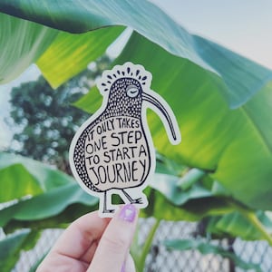 May include: A black and white sticker of a kiwi bird with the text "It only takes one step to start a journey".