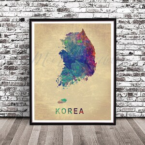 May include: A watercolor print of the outline of South Korea on a beige background. The print is in shades of blue, green, red, and purple. The word "KOREA" is printed in black at the bottom of the print.