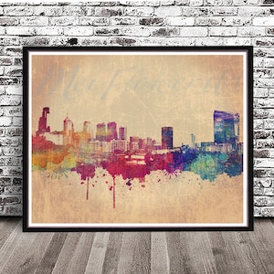 May include: A watercolor painting of a city skyline with colorful splashes of paint. The skyline is silhouetted against a beige background.