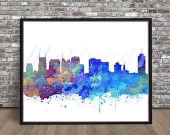 May include: A watercolor painting of the Nashville skyline in shades of blue, purple, and orange. The cityscape is silhouetted against a white background with splatters of paint.