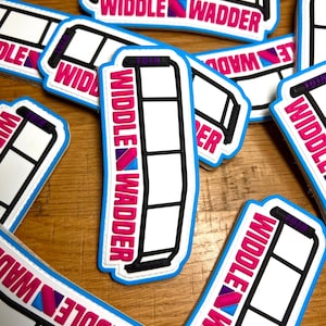 May include: A collection of white, black, and blue stickers with the text "Widdle Wadder." The stickers have a rectangular shape with a ladder-like design and a blue border. The text is in pink and blue.