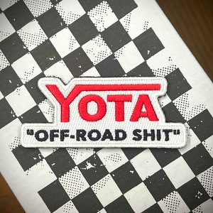 May include: White embroidered patch with red lettering that says "YOTA" and "OFF-ROAD SHIT" in black lettering.