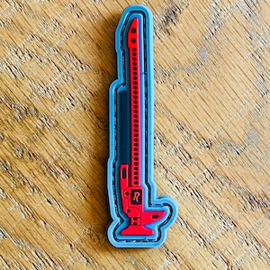 May include: A red and black car jack with a gray outline. The jack has a handle and a base. The jack is a common tool for changing tires.