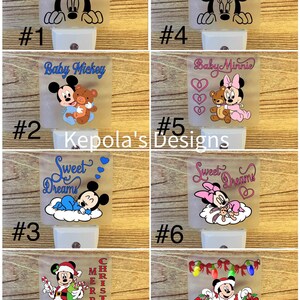 May include: A collection of decorative night lights featuring Disney characters. Designs include Mickey Mouse, Minnie Mouse, and baby versions, with themes like "Sweet Dreams" and Christmas. Each light has a white base and a frosted, rectangular shade.