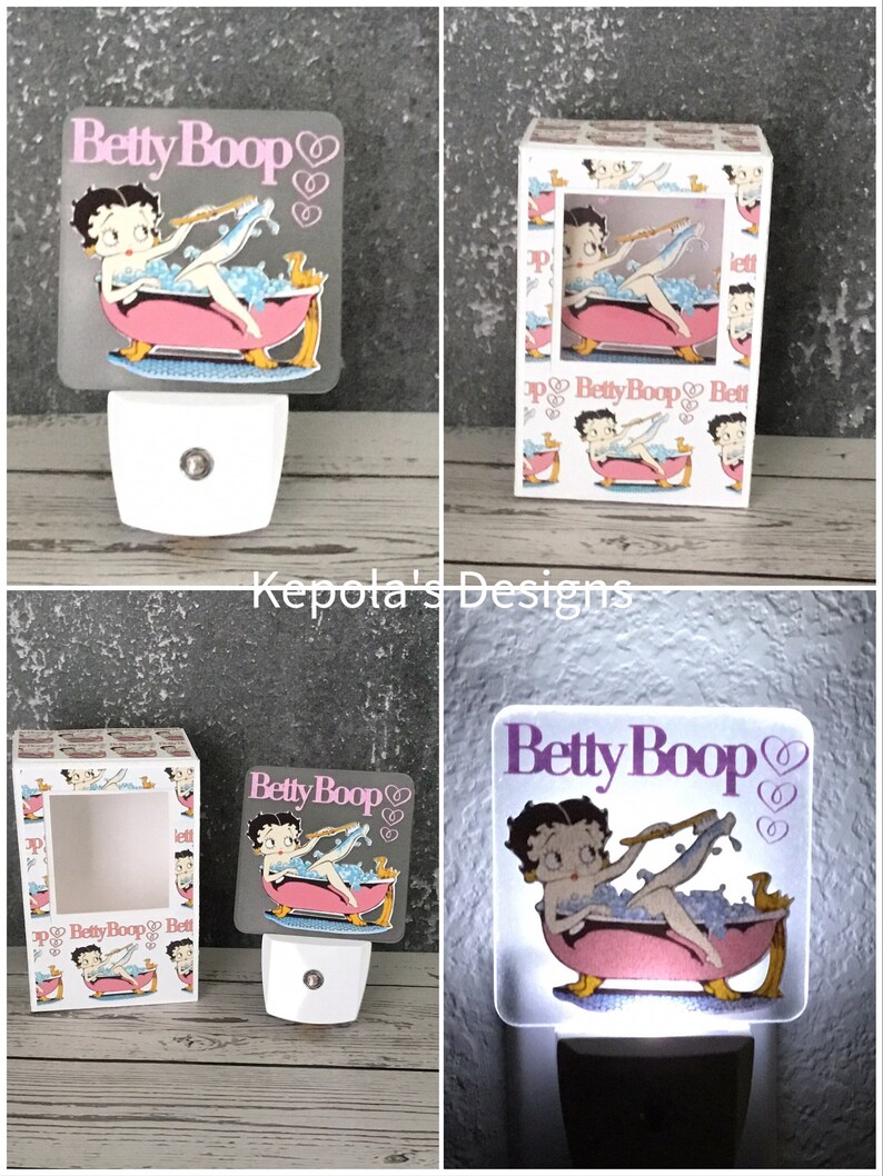 May include: A Betty Boop night light featuring the cartoon character in a pink bathtub with bubbles. The night light has a white base and a square, frosted acrylic panel with the Betty Boop logo and heart designs.