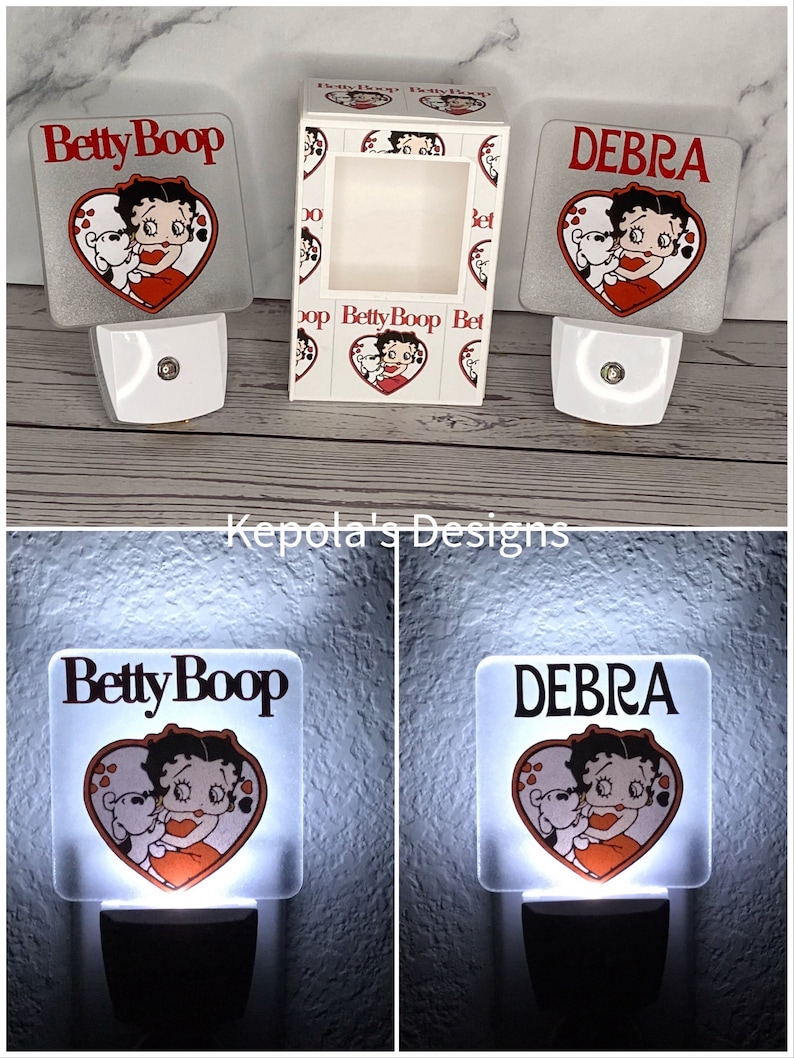 May include: White night lights featuring a Betty Boop design with a heart-shaped graphic. One night light is personalized with the name "Debra". The packaging box also features the Betty Boop design.