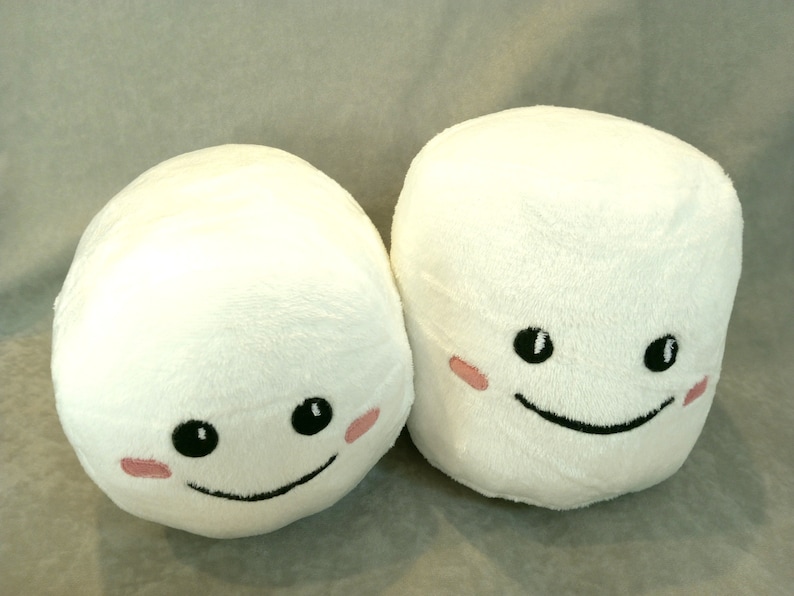 May include: Two white plush marshmallow toys with embroidered smiling faces and pink cheeks.
