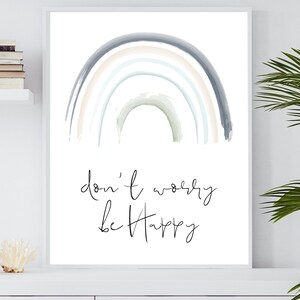 Könnte beinhalten: Ein Aquarell-Regenbogen in Pastellfarben wie Blau, Grün und Rosa. Der Regenbogen ist auf weißem Hintergrund gemalt, mit dem Text "Mach dir keine Sorgen, sei glücklich" in schwarzer Kursivschrift.