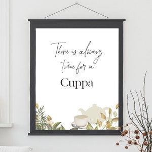 Peut inclure: Une affiche blanche avec du texte noir qui dit "There is always time for a Cuppa". L'affiche présente une illustration aquarelle d'une théière et d'une tasse à thé avec des feuilles vertes.