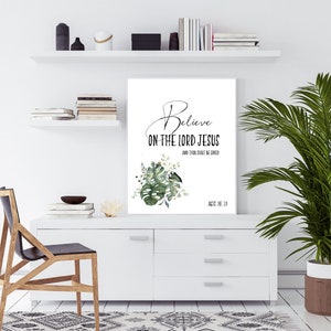 May include: A white printable wall art with a green leafy design and the text "Believe on the Lord Jesus and thou shalt be saved" with the scripture reference "Acts 16:31".