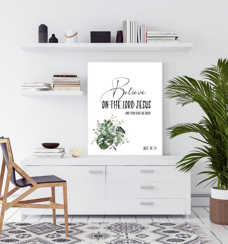 May include: A white printable wall art with a green leafy design and the text "Believe on the Lord Jesus and thou shalt be saved" with the scripture reference "Acts 16:31".