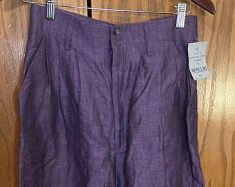 Könnte beinhalten: Lilafarbene Leinenhose mit Knopfleiste und Falten. Die Hose hat ein Etikett mit der Aufschrift "This is a washable linen garment by For Pete's Sake."