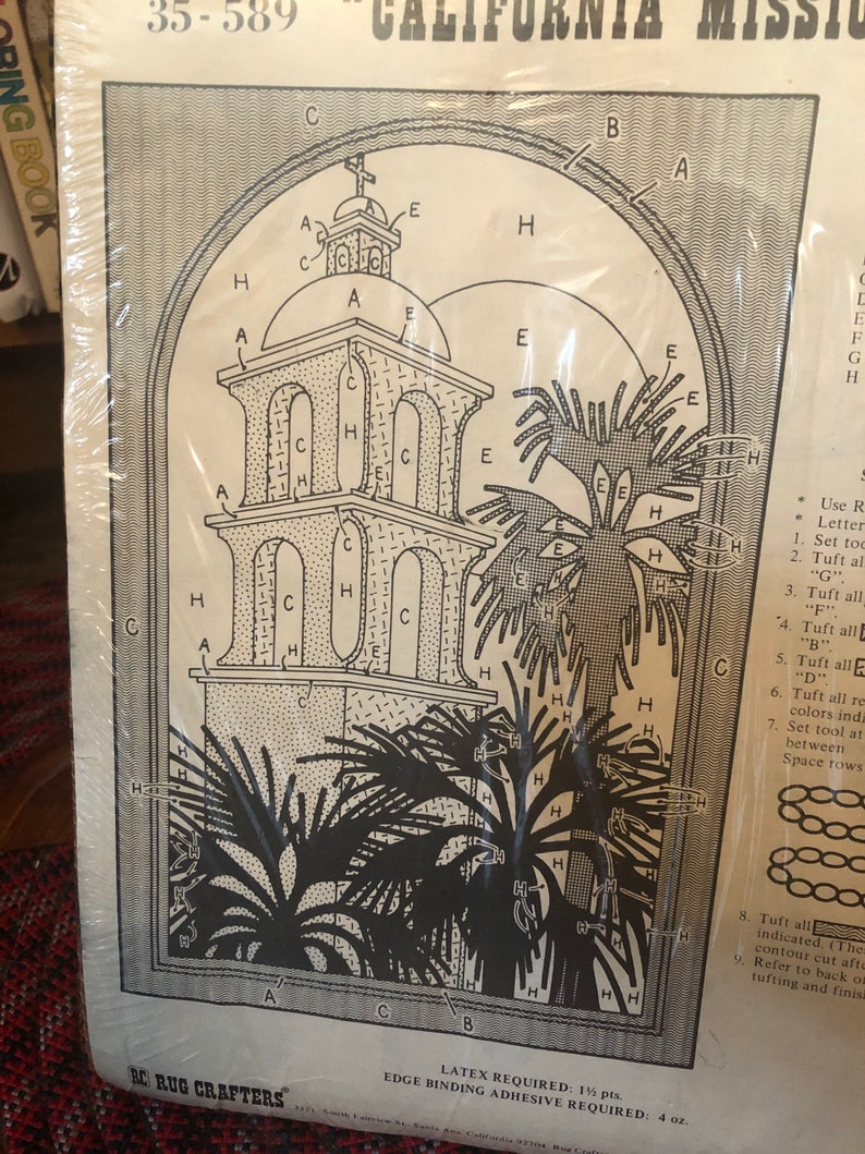 May include: A black and white line drawing of a California mission with a bell tower, palm trees, and instructions for rug hooking. The instructions include letters and numbers to indicate the order of the steps. The text on the page reads "35-589 California Mission" and "RC Rug Crafters".