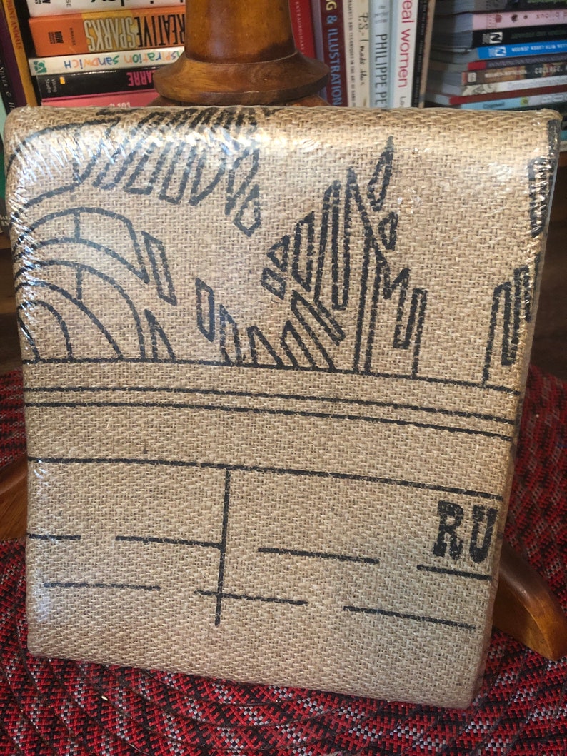 May include: A brown burlap book cover with black geometric designs and the word "RU" printed on the bottom right corner.