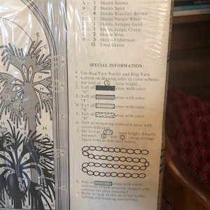 May include: A rug hooking pattern with a color scheme and instructions. The pattern includes a variety of colors, including sienna, sand, brown, white, gold, green, moss, and fisherman. The instructions include a list of materials, a color chart, and a step-by-step guide to hooking the rug.