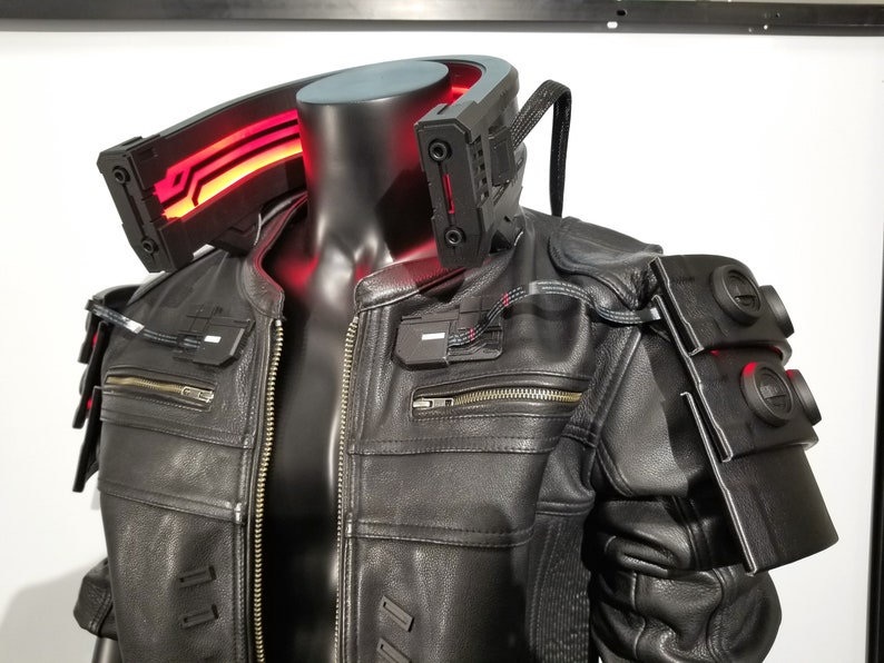 May include: A black leather jacket with a red light-up collar and black accents. The jacket has a zipper closure and multiple pockets.