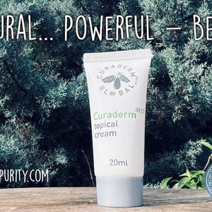 May include: A white tube of Curaderm topical cream with the text "NATURAL... POWERFUL - BEC-5". The tube has a gray cap and contains 20ml of cream. The background features green foliage and the website ANCIENTPURITY.COM.