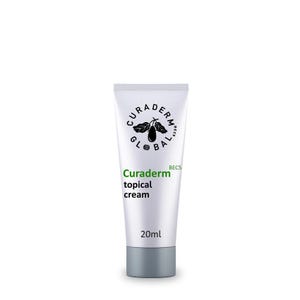 May include: A white tube of Curaderm topical cream with a gray cap. The tube features the brand name and product description in green and black text, along with a logo. The tube contains 20ml of cream.