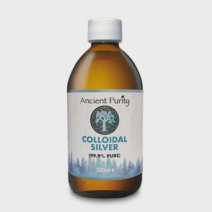 May include: A brown glass bottle with a white cap, labeled "Ancient Purity" and "Colloidal Silver (99.9% Pure)". The label features a tree design and a forest scene at the bottom. The bottle contains 500ml of liquid.