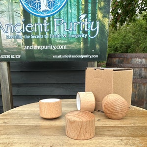 May include: Four wooden spinning tops, two with a white top and two with a natural wood finish. The tops are on a wooden table. The tops are packaged in a brown cardboard box.