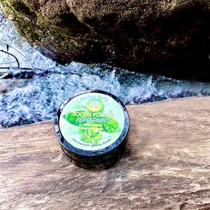 May include: A round black container of peppermint tooth powder with a green label featuring a tree logo and the text: Ancient Purity, TOOTH POWDER, PEPPERMINT, 100% Natural, Made with calcium, Free From SLS, glycerine, fluoride.