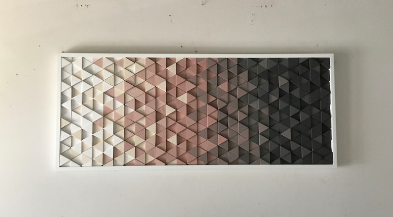 May include: A wall art piece made of a gradient of triangles in shades of white, pink, and gray. The triangles are arranged in a geometric pattern.