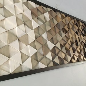 May include: A framed wall art piece made of wood triangles in various shades of brown, gray, and white. The triangles are arranged in a geometric pattern, creating a gradient effect from light to dark.