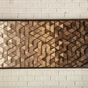 May include: A wooden wall art piece made of a gradient of brown triangles. The triangles are arranged in a geometric pattern, creating a modern and abstract design.