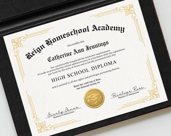 Pode incluir: Um diploma do ensino médio da Reign Homeschool Academy, com bordas douradas ornamentadas e texto. O diploma é apresentado em uma pasta preta com interior vermelho. O texto inclui o nome do graduado, Catherine Ann Jennings, e a data.