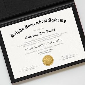 May include: A High School Diploma from Reighn Homeschool Academy, presented in a black folder. The diploma features the name Catherine Ann James, a gold seal, and signatures. The text is in black on a white background.